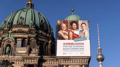 A vaccine campaign poster hangs at Berlin Cathedral in March. The government is facing some heat for its absurd approach on the public awareness campaigns. 