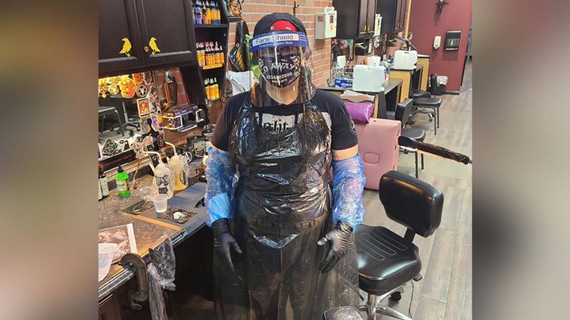 Mitchell stands in full PPE, ready for tattooing.