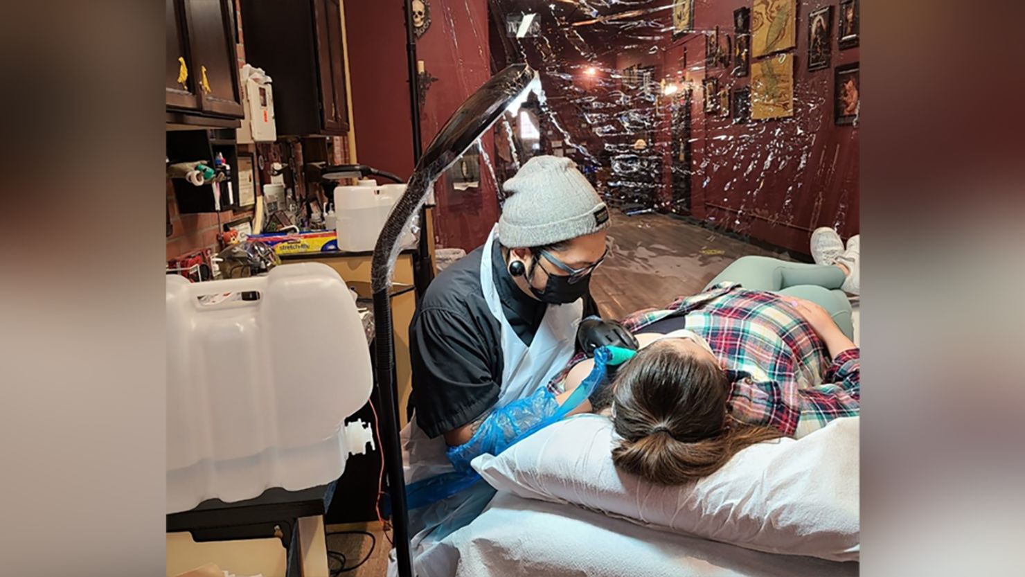 Kayo Sumbillo, an artist at Black Raven Tattoo in California, tattoos a client in the midst of the Covid-19 pandemic. 