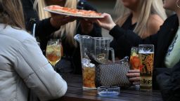A group of friends eat pizza at a table outside the Water Lane Boathouse bar in Leeds, northern England on April 12, 2021, as coronavirus restrictions are eased across the country in step two of the government's roadmap out of England's third national lockdown. - Britons on Monday toasted a significant easing of coronavirus restrictions, with early morning pints -- and much-needed haircuts -- as the country took a tentative step towards the resumption of normal life. Businesses including non-essential retail, gyms, salons and outdoor hospitality were all able to open for the first time in months in the second step of the government's roadmap out of lockdown. (Photo by Lindsey Parnaby / AFP) (Photo by LINDSEY PARNABY/AFP via Getty Images)
