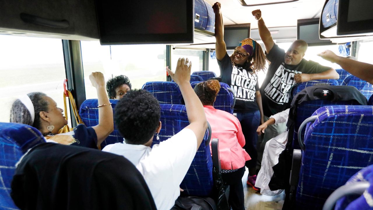 In this August 2018 photo, Black Voters Matter Fund co-founders LaTosha Brown, left, and Cliff Albright, right, lead Mississippi grassroots partners in some empowerment cheers aboard a bus tour to Greenville, Mississippi.
