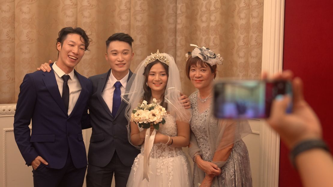 Leung and Liao pose on their big day with Leung's brother (left) and mother (right).