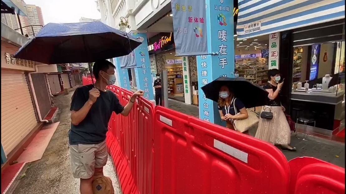 Leung and Liao stand on opposite sides of the Ching Ying Street border, unable to touch each other.