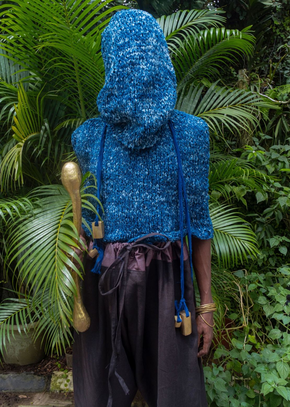 A hand-knitted "post-adire" cape blouse, made of adire patterned fabric, dyed with natural indigo, paired with 
Yoruba wide trousers.