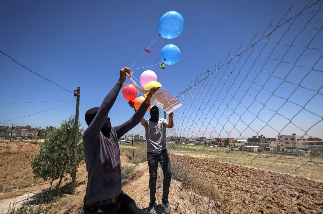 Masked Palestinian supporters of the Islamic Jihad movement prepare incendiary balloons east of Gaza city, to launch across the border fence towards Israel on June 15.