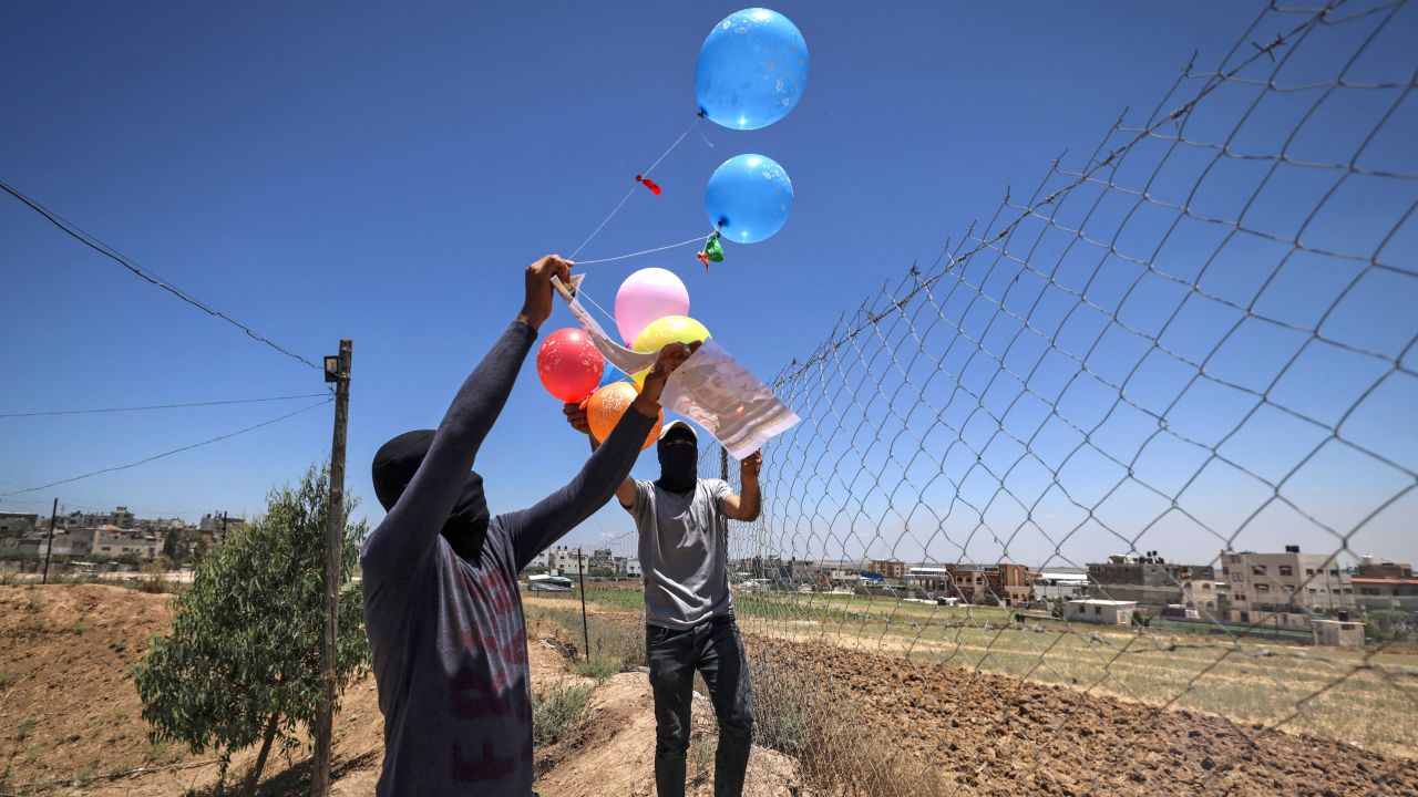 Masked Palestinian supporters of the Islamic Jihad movement prepare incendiary balloons east of Gaza city, to launch across the border fence towards Israel on June 15.