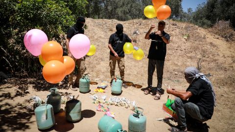 Militants east of Gaza City prepare incendiary balloons to launch across the border fence towards Israel on Wednesday.