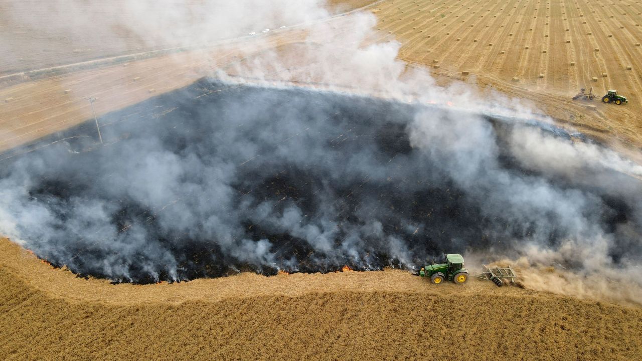 Smoke billows from a burnt-out field near the southern Israeli kibbutz of Nir Am on May 9, 2021, after a fire caused by incendiary balloons launched from Gaza.