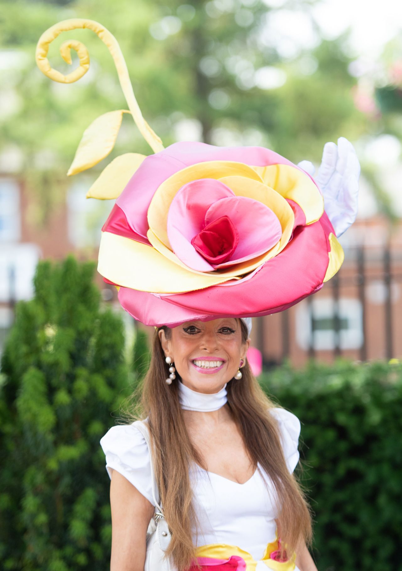 A giant rose complete with freestanding stem is the crowning feature of this racegoers look.
