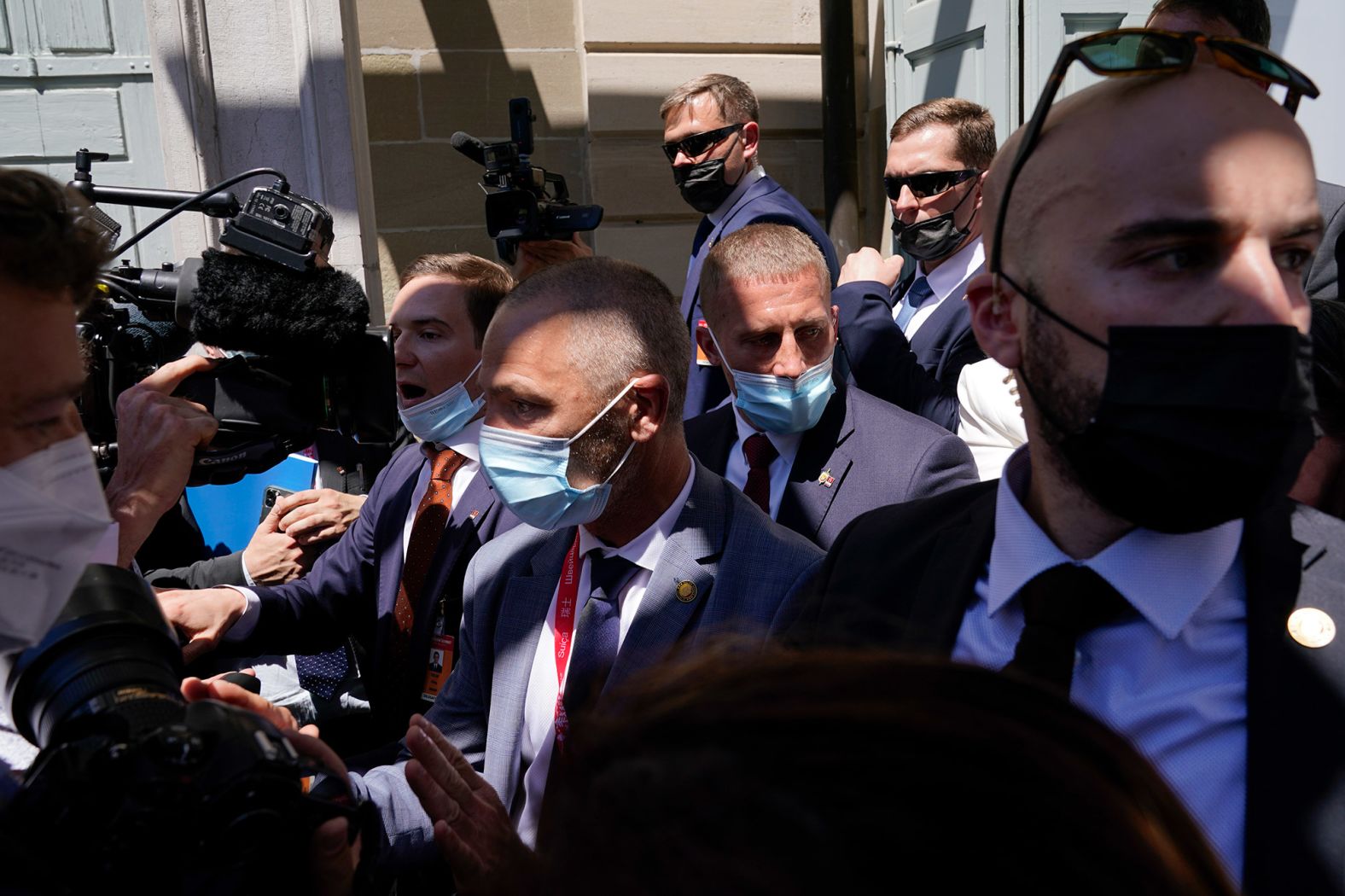 Security personnel corral members of the press pool.