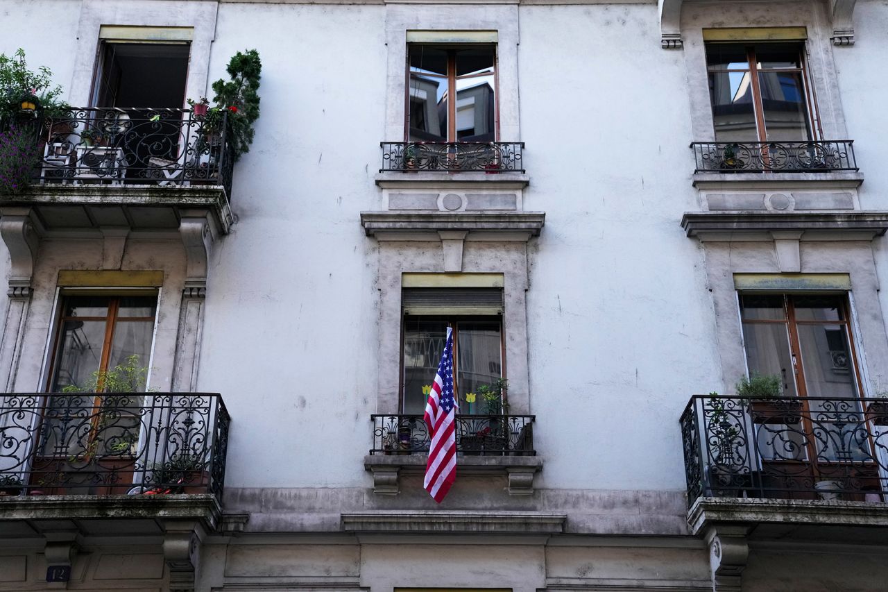The window of a residential building in Geneva is decorated with an American flag.