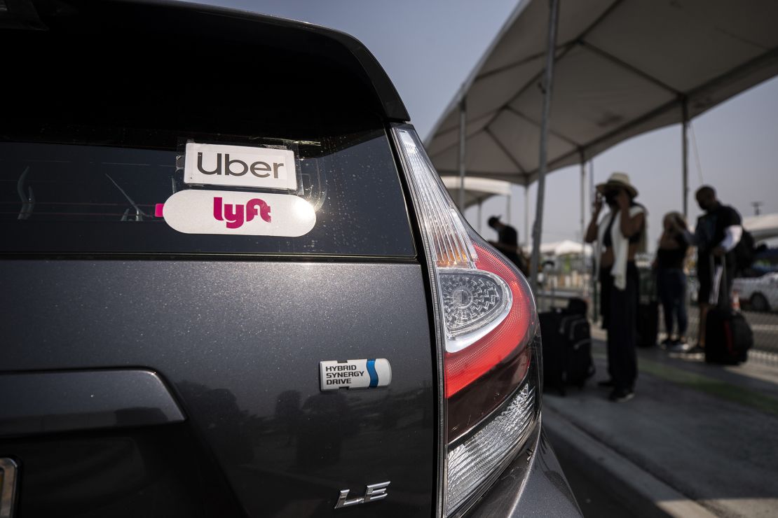 Uber and Lyft stickers are displayed on a car at LAX airport in Los angeles during a Mobile Workers Alliance rally on August 20, 2020.