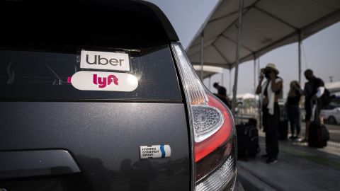 Uber and Lyft stickers are displayed on a car at LAX airport in Los angeles during a Mobile Workers Alliance rally on August 20, 2020.