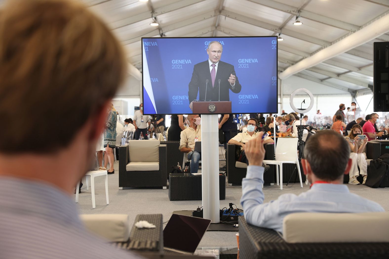 Journalists in the nearby media center watch Putin's news conference after the summit. Putin described his meeting with Biden as "productive" on the whole. "It was substantive, concrete and took place in an atmosphere that was aimed at achieving results," he told reporters.