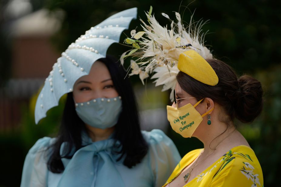 Milliners Anna Gilder (right) and Yuan Li wore equally ornate hats to the races. Gilder's mask reads "Only remove for champagne." 