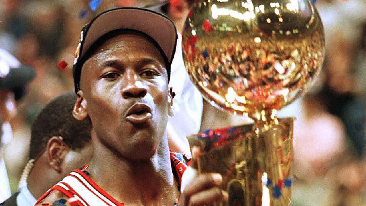 Jordan lifts up his fifth NBA championship trophy after a Game Six win in the 1997 NBA Finals.