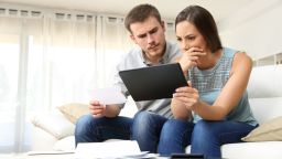 underscored upset concerned couple looking at tablet in distress