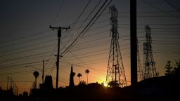 The sun sets behind power lines in Rosemead, California on June 14, 2021, amid an early season heatwave across much of California this week. (Photo by Frederic J. BROWN / AFP) (Photo by FREDERIC J. BROWN/AFP via Getty Images)