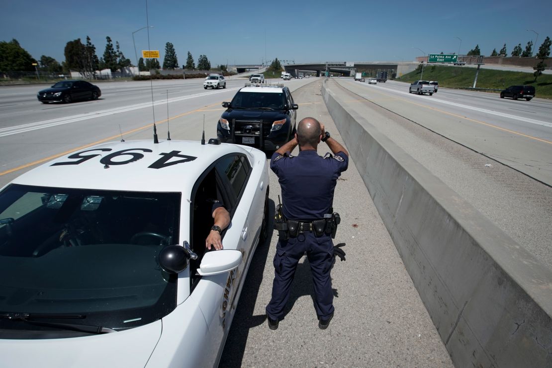 California Highway Patrol officer Matthew Musselmann uses a laser gun to detect speeders on Interstate 5 on April 23, 2020, in Anaheim.