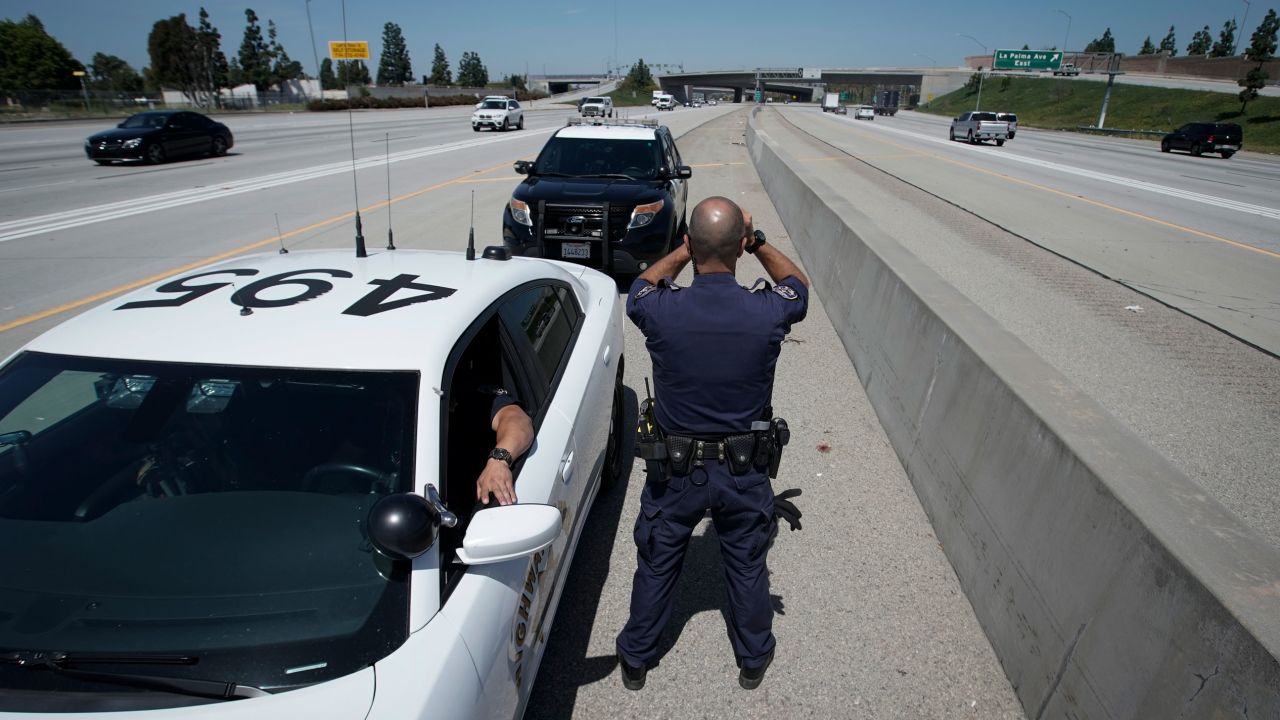 California Highway Patrol officer Matthew Musselmann uses a laser gun to detect speeders on Interstate 5 on April 23, 2020, in Anaheim.