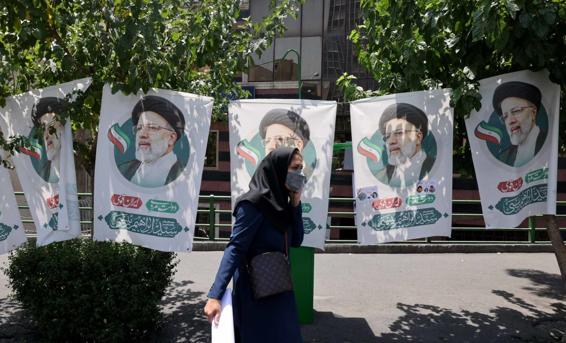 An Iranian woman walks past banners of ultraconservative cleric and presidential candidate Ebrahim Raisi, in Tehran, on June 17, 2021.