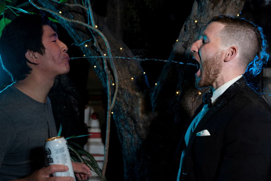 Jeffrey Shiau, a volunteer from the crowd, spits water into the mouth of Sam Kaufman, a performer from the Human Fountains, during a "reopening party" in Los Angeles on Tuesday, June 15. California lifted most of its Covid-19 restrictions Tuesday as part of a grand reopening in which the state ended capacity limits, physical distancing and — at least for those vaccinated — mask requirements.