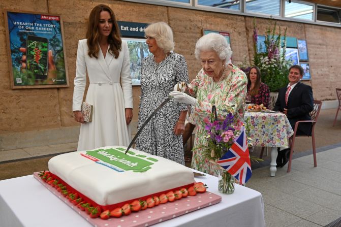 Britain's Queen Elizabeth II <a href="https://www.cnn.com/2021/06/12/uk/queen-sword-cake-cut-gbr-scli-intl/index.html" target="_blank">uses a sword to cut a cake </a>at a charity event in St. Austell, England, on Friday, June 11. She was joined by Catherine, the Duchess of Cambridge, left, and Camilla, the Duchess of Cornwall.