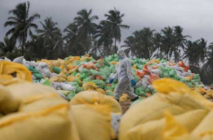 A member of the Sri Lankan Navy walks past sacks of collected debris in Ja-Ela, Sri Lanka, on Monday, June 14. The debris is from the container ship <a href="https://www.cnn.com/2021/06/15/asia/sri-lanka-ship-captain-arrested-intl-hnk/index.html" target="_blank">that caught fire last month</a> off the coast of Colombo.