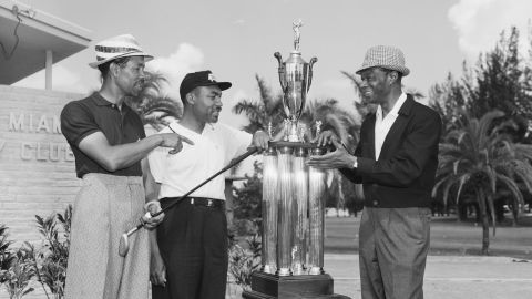 Sifford is presented with the North-South Negro Golf Tournament trophy by night club celebrity Nat "King" Cole. 