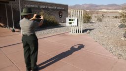 DEATH VALLEY NATIONAL PARK, CALIFORNIA - AUGUST 17: A park ranger takes a photo of an unofficial thermometer at Furnace Creek Visitor Center on August 17, 2020 in Death Valley National Park, California. The temperature reached 130 degrees at Death Valley National Park on August 16, hitting what may be the hottest temperature recorded on Earth since at least 1913, according to the National Weather Service. Park visitors have been warned, 'Travel prepared to survive.' (Photo by Mario Tama/Getty Images)