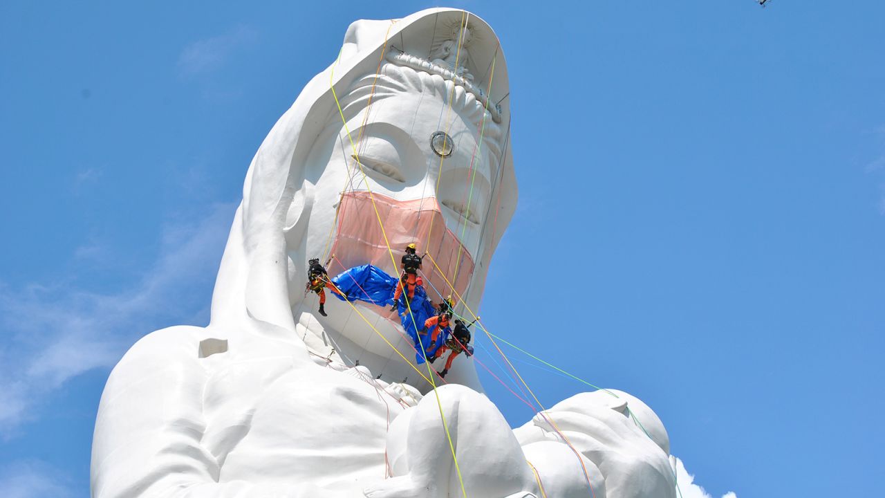 Workers place a mask on a statue of Buddhist goddess at Houkokuji Aizu Betsuin temple in Aizuwakamatsu, Japan on June 15.