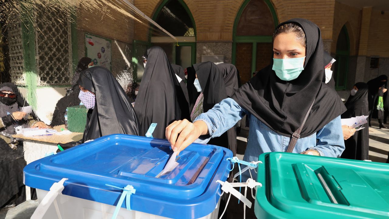 An Iranian woman casts her ballot for presidential election at a polling station in Tehran, on June 18, 2021.