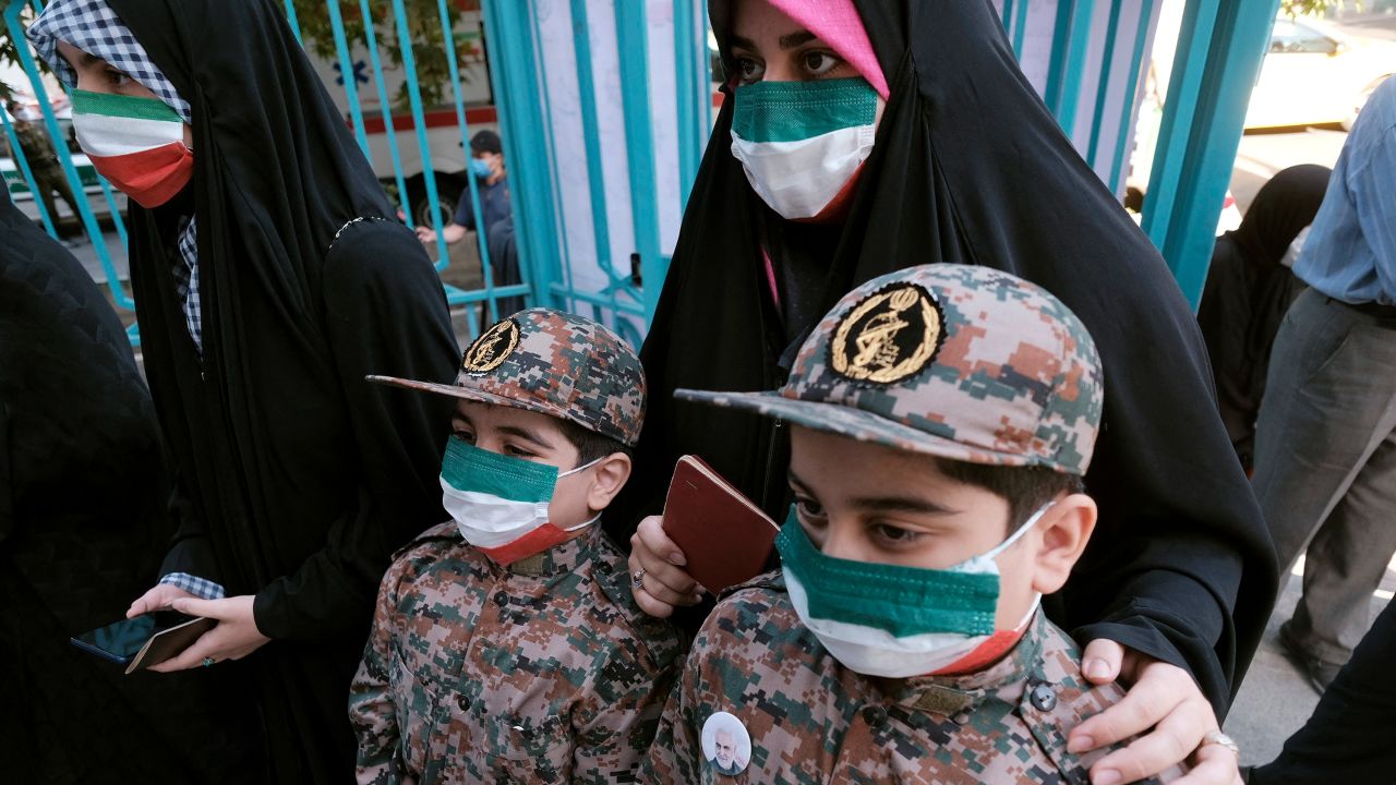 A mother and her children, wearing Islamic Revolutionary Guard Corps' uniforms, line up at a polling station on Friday.