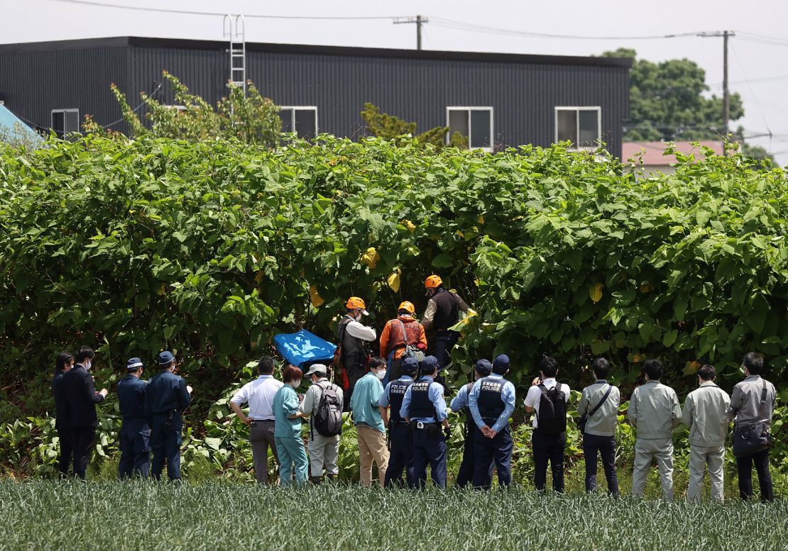 Police officers and members of a hunting group search for a brown bear on the loose in Sapporo, Japan, on June 18.