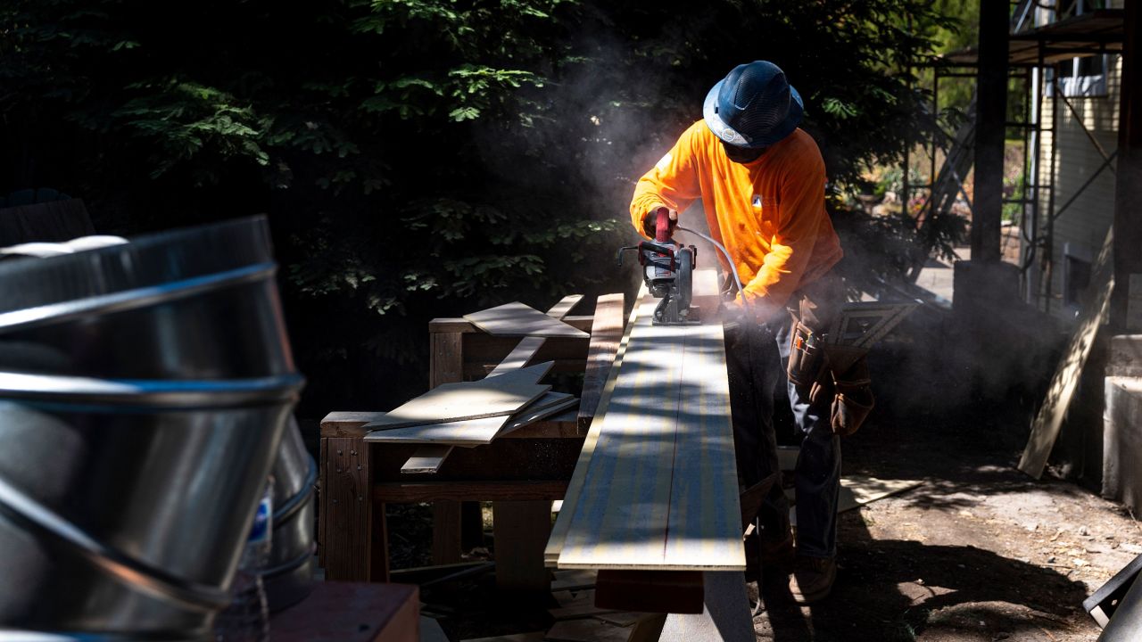 A contractor uses a saw to cut siding for a house under construction in Walnut Creek, California, US on June 17, 2021.