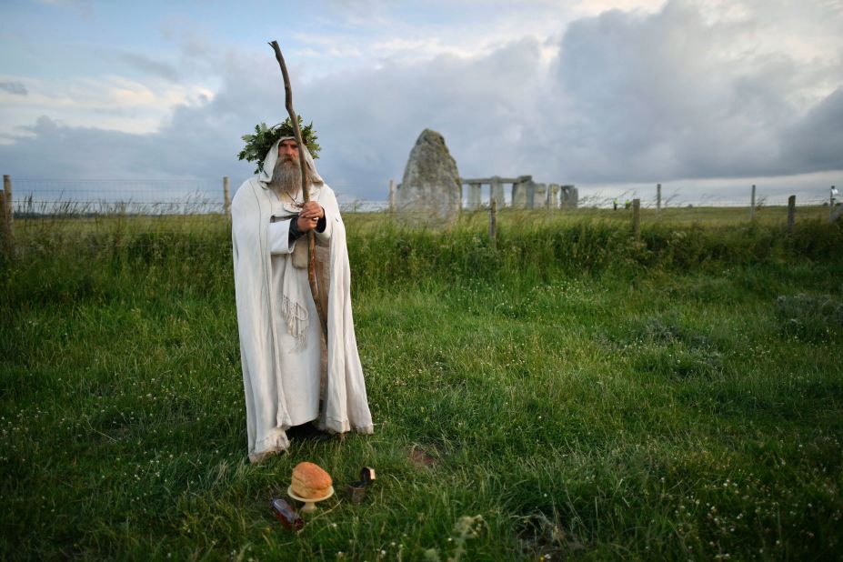 An archdruid performs a ritual near the cordoned off Stonehenge near Salisbury, England, during summer solstice 2020. The coronavirus pandemic has prevented druids, pagans and partygoers from watching the sun rise at Stonehenge in person for the past two years.