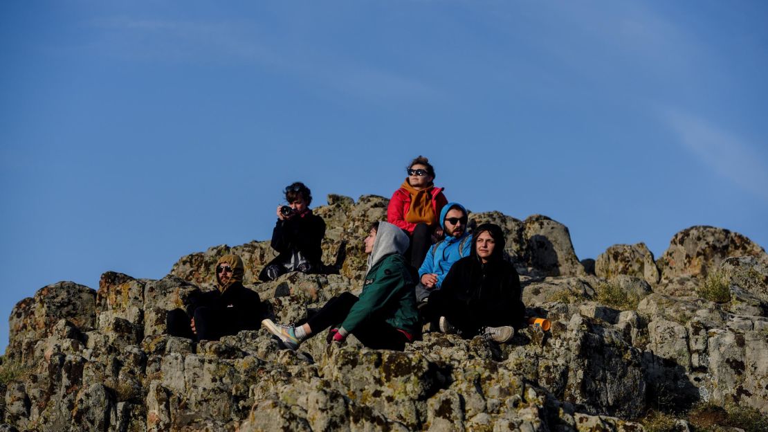 People watch as the sun rises on a rocky crest filled with astronomical markers at the megalithic observatory of Kokino in North Macedonia on summer solstice 2020.