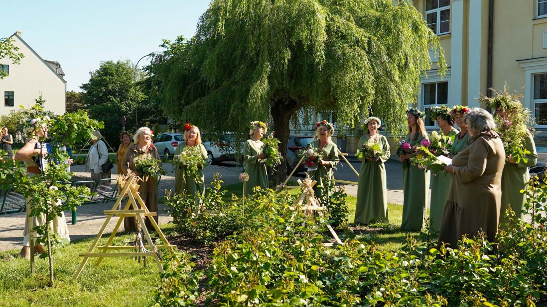 In Latvia, women wear flower crowns and dress in traditional costumes singing folk songs.