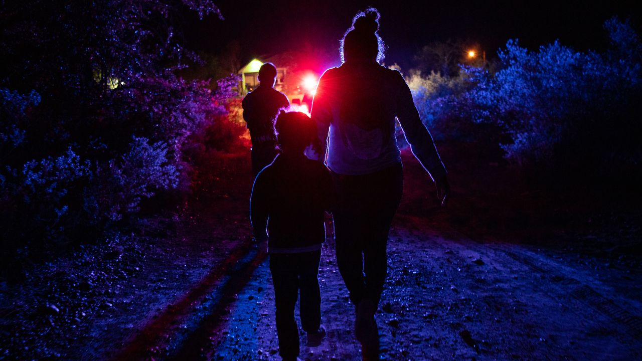 Immigrants seeking asylum walk to be processed at a border patrol processing facility after crossing into the United States on June 17, 2021. 