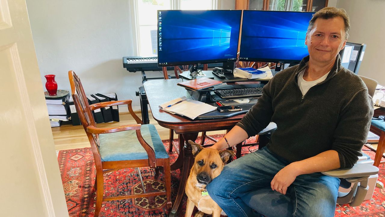 Robert Allenby in his home office with his dog Anna in San Diego, California.