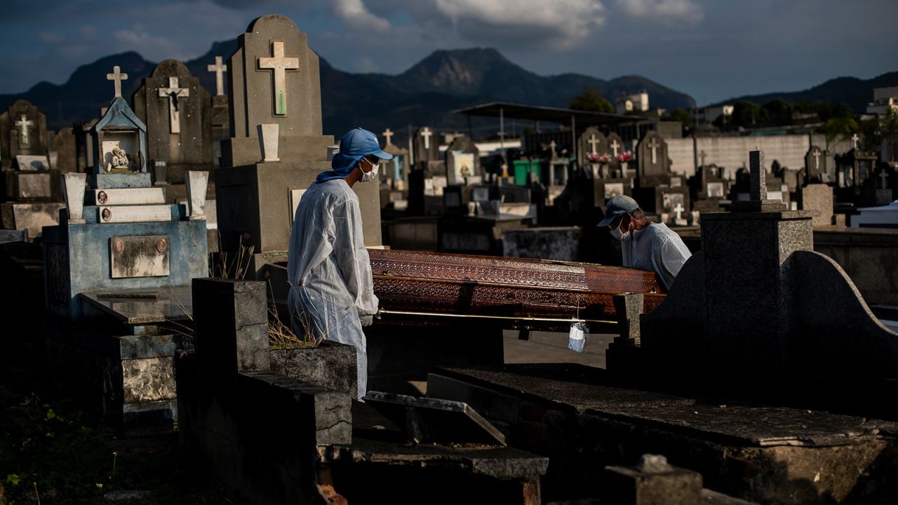 Cemetery workers carry the coffin of a person who died from Covid-19 related complications at the Inhauma cemetery in Rio de Janeiro, Brazil, on June 18, 2021.