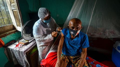 A man is vaccinated against Covid-19 by a health worker in a remote area of Moju, Para state, Brazil on April 16, 2021.