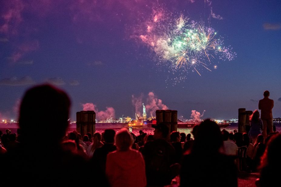 People watch fireworks in front of the Statue of Liberty after the state of New York lifted most of its Covid-19 restrictions on Tuesday, June 15. Gov. Andrew Cuomo announced that 70% of adults in New York had received at least one dose of a Covid-19 vaccine.