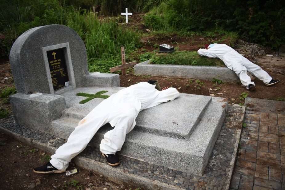 Exhausted grave diggers rest between funerals at a cemetery designated for Covid-19 victims in Bandung, Indonesia, on Tuesday, June 15.