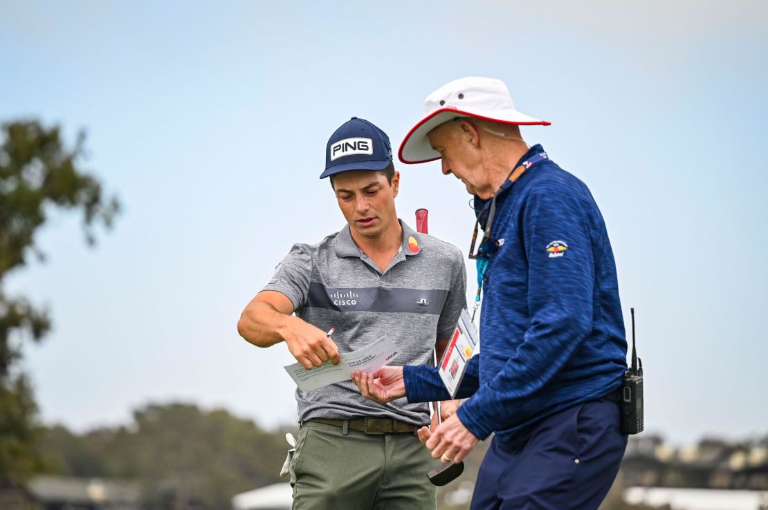 Hovland (left) reviews his scorecard  during the second round of the US Open at Torrey Pines, California. 