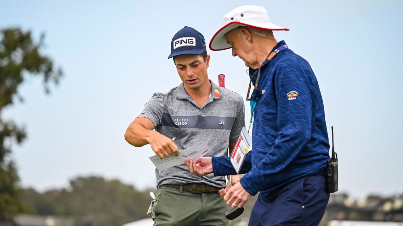 Hovland (left) reviews his scorecard  during the second round of the US Open at Torrey Pines, California. 