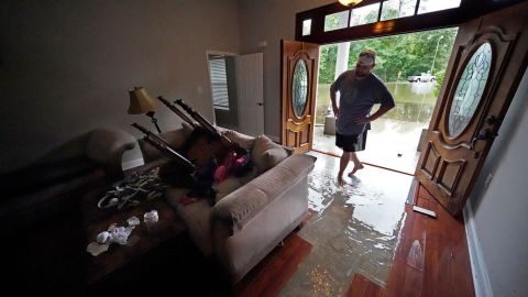 In Slidell, Louisiana, Danny Gonzales walks in his flooded house as water recedes Saturday.