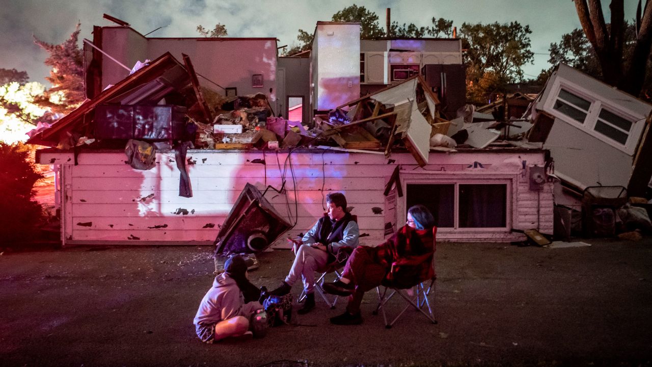 Bridget Casey sits in the driveway of her severely damaged home with her son Nate, 16, and daughter Marion, 14, after a storm swept through Woodridge, Illinois.