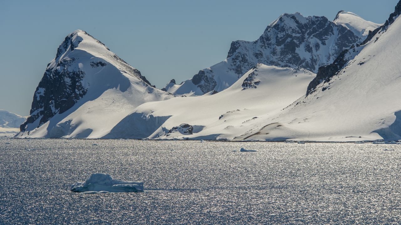 View of backlit mountains in the Gerlache Strait at Cuverville Island in the Antarctic Peninsula region.