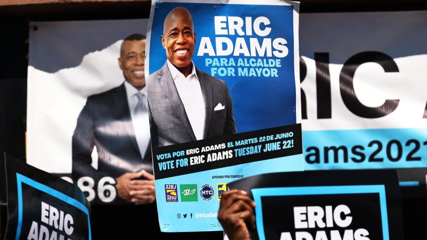 NEW YORK, NEW YORK - JUNE 17: People hold up campaign signs as New York City mayoral candidate Eric Adams speaks during a press conference outside his campaign office on June 17, 2021 in the Harlem neighborhood of Manhattan in New York City. Adams held a press conference to receive the endorsement of Keith L.T. Wright, leader of the New York County Democrats and former NY Governor David Paterson, a day after the final official Democratic primary debate for New York City mayor on Wednesday night. On Wednesday, Adams was also endorsed by Terrence Floyd, a brother of the late George Floyd, who was killed by Minneapolis police last Summer. Adams leads in the polls with Primary Election Day less than a week a way. (Photo by Michael M. Santiago/Getty Images)